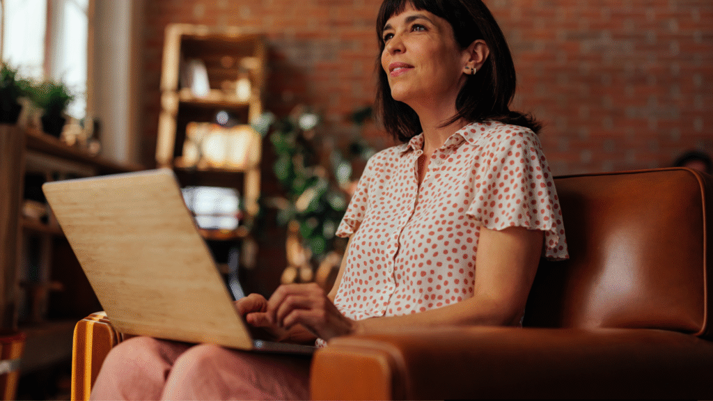 A woman writing on a laptop.