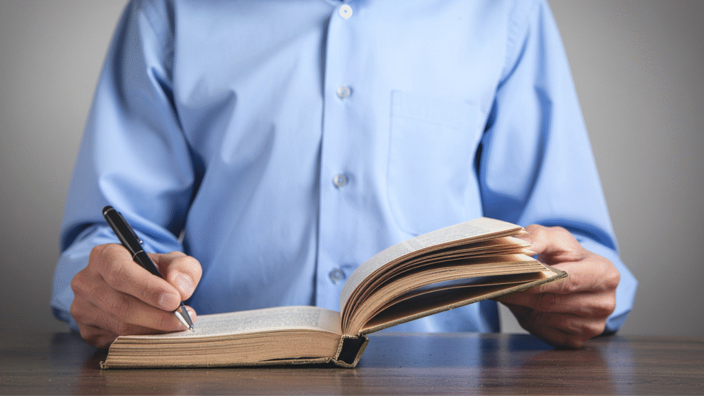 A man writing in a journal.